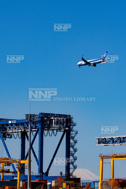 クレーンの上空を飛ぶ飛行機