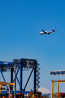 クレーンの上空を飛ぶ飛行機